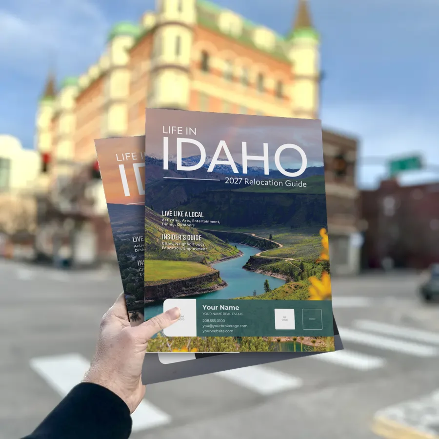 A printed 2027 Life in Idaho Area Guide with the River Bend cover, held in downtown Boise